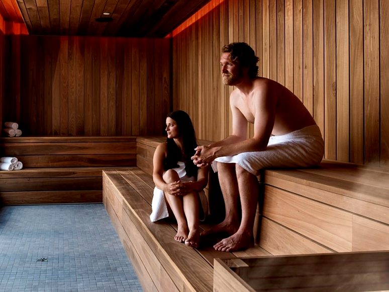 Two guests relaxing in the wood-panelled sauna at the Fox Harb'r spa