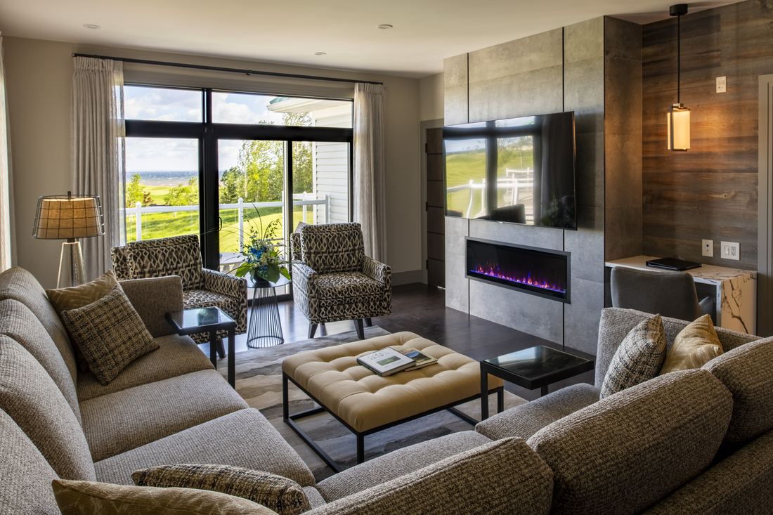 A Fox Harb'r suite living room with a fireplace and a view of the grounds