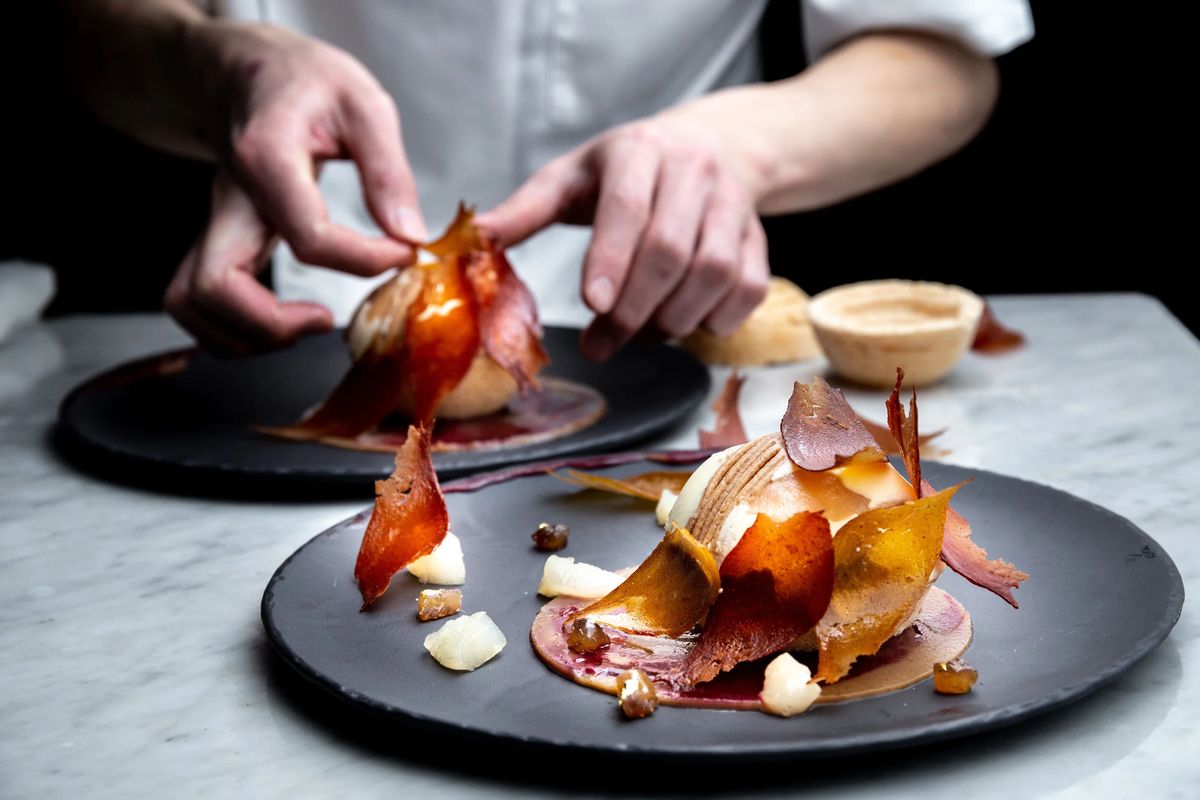 A chef finishing plated desserts