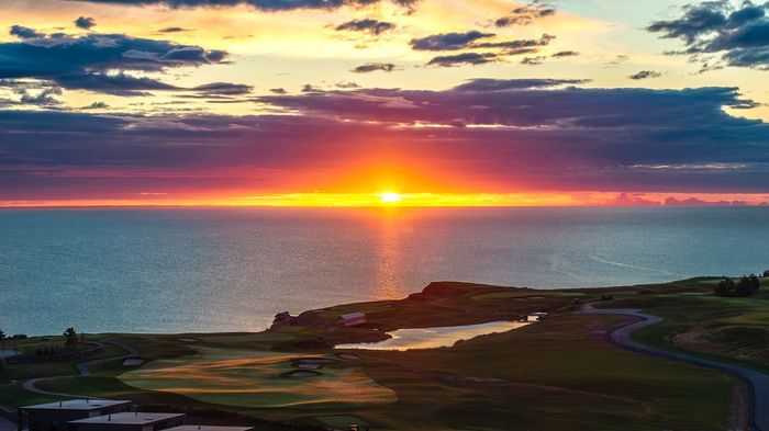 The 14th hole on the Ocean Course and the Strait with the sun low on the water