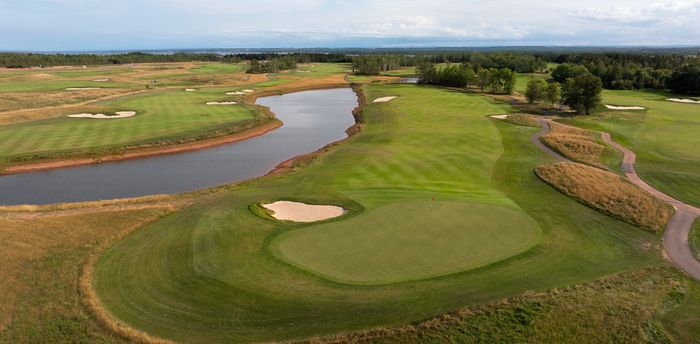 Aerial view of the 9th green on the Vineyard Course, ringed by bunkers beside a pond